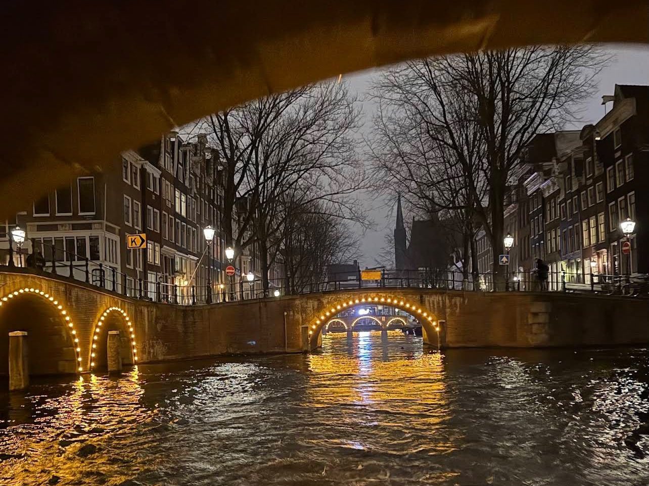 A canal boat trip under Amsterdam's lit bridges