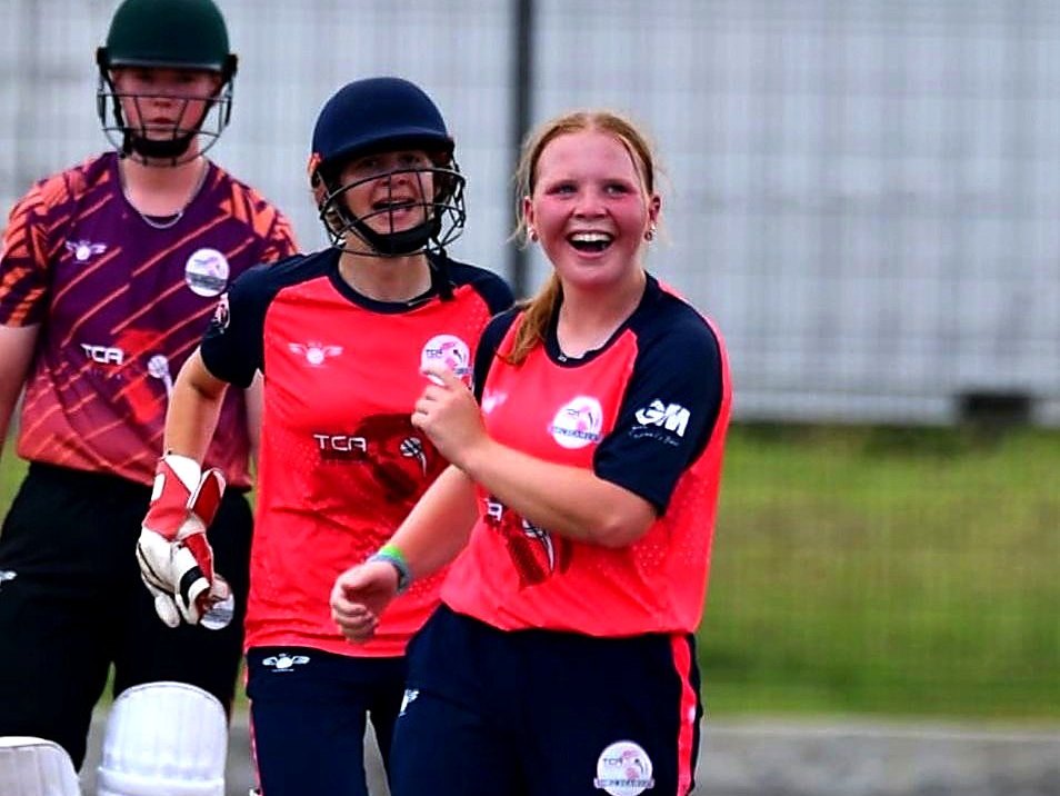 Players celebrating a wicket in a girls' tournament match