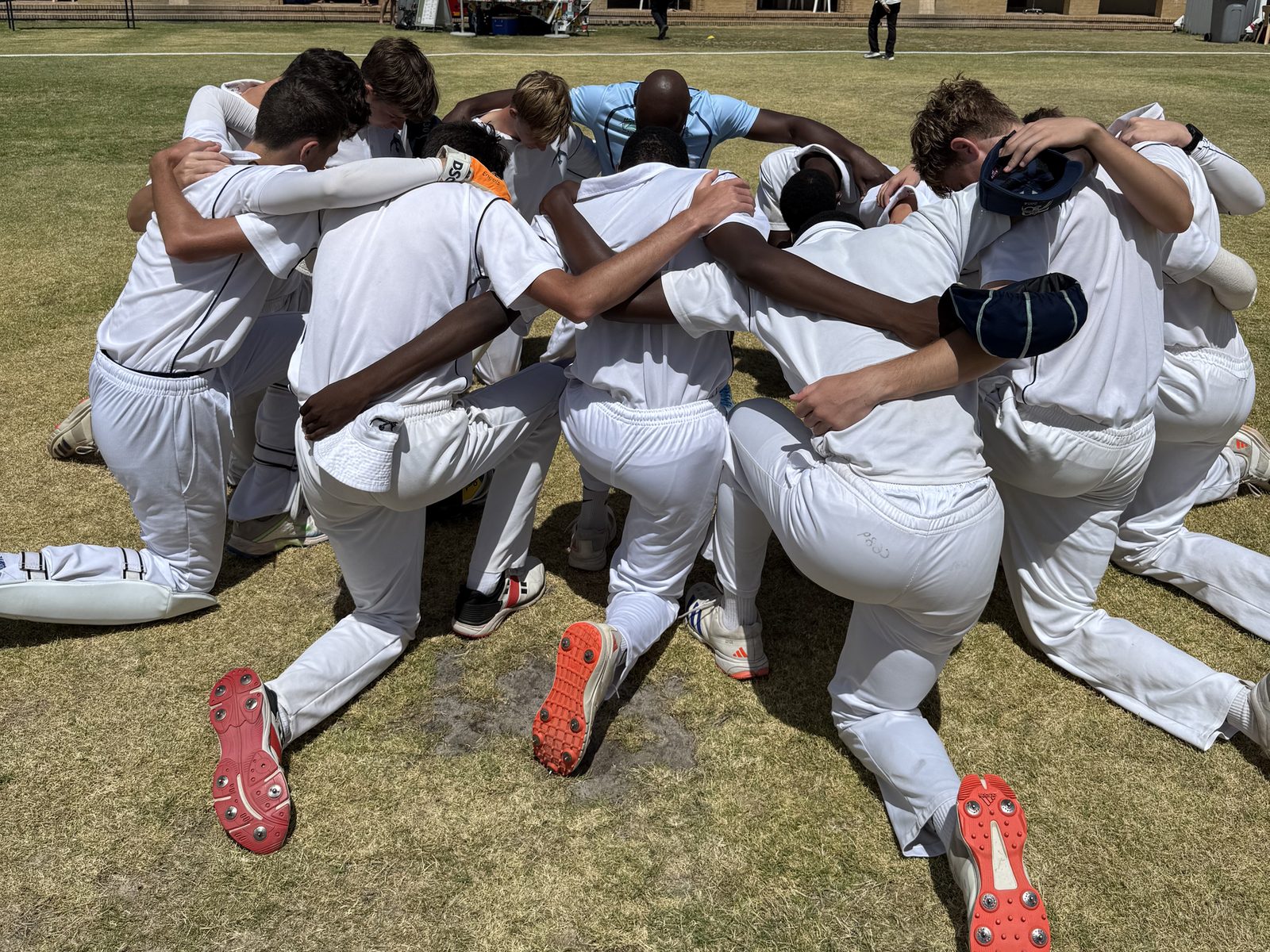 A team huddle in front of a Cape Town pavilion